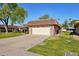 Side view of a well-kept home featuring an attached two-car garage and mature trees at 9802 W Shasta Dr, Sun City, AZ 85351