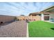 A low maintenance backyard featuring gravel, artificial grass and a seating area with a BBQ at 10545 E Texas Ave, Mesa, AZ 85212