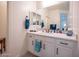 Bright bathroom with double vanity featuring sleek white cabinets and a large mirror at 10545 E Texas Ave, Mesa, AZ 85212