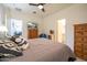 Spacious bedroom featuring a ceiling fan, dresser, and an ensuite bathroom at 10545 E Texas Ave, Mesa, AZ 85212