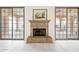 Close up view of the stone fireplace in a living room with marble floors and sliding doors at 10895 E Mission Ln, Scottsdale, AZ 85259