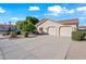 View of a two car garage with an expansive driveway and desert landscaping at 10895 E Mission Ln, Scottsdale, AZ 85259