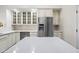 This open kitchen features white cabinets, stainless steel appliances, and a center island with quartz countertops at 10895 E Mission Ln, Scottsdale, AZ 85259