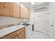 Well-lit laundry room featuring modern appliances, ample storage, and tiled floor at 10895 E Mission Ln, Scottsdale, AZ 85259