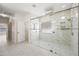 Luxurious glass shower with rain head, marble tile, and a window for natural light at 10895 E Mission Ln, Scottsdale, AZ 85259