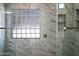 Close up on the shower window, marble tiles, and sleek shower head fixtures at 10895 E Mission Ln, Scottsdale, AZ 85259