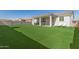 Large backyard features artificial grass, a covered patio, and plenty of space for outdoor enjoyment at 11441 W La Reata Ave, Avondale, AZ 85392