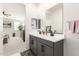 A well-lit bathroom featuring a double sink vanity and a view into the Primary bedroom, promoting openness at 11441 W La Reata Ave, Avondale, AZ 85392