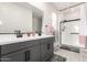 Modern bathroom with a dual sink vanity, large mirror, and a glass-enclosed shower with neutral colors at 11441 W La Reata Ave, Avondale, AZ 85392