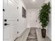 Bright hallway with grey wood floors, white doors and walls, decorative painting and plant at 11441 W La Reata Ave, Avondale, AZ 85392