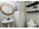 Stylish powder bathroom with pedestal sink, framed mirror, and modern decor for a chic and functional space at 1180 E Ibis St, Gilbert, AZ 85297