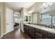 Bathroom featuring granite countertops, wood-look flooring, double sinks, and two entry ways at 1180 E Ibis St, Gilbert, AZ 85297