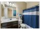 Well-lit bathroom featuring a dark vanity with a white countertop and a blue and white shower curtain at 1180 E Ibis St, Gilbert, AZ 85297