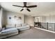 Cozy living room with a sectional sofa, ceiling fan, and Gathering photos on the wall above a staircase at 1180 E Ibis St, Gilbert, AZ 85297