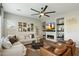 Bright living room features a fireplace, built-in shelving, comfortable seating, and a modern ceiling fan at 1180 E Ibis St, Gilbert, AZ 85297