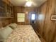 A bedroom with paneled walls, a ceiling fan, a floral bedspread, built-in storage, and natural light at 1281 S Sioux Dr, Apache Junction, AZ 85119