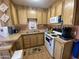 A full kitchen view with natural wood cabinetry, a double basin stainless steel sink, and white appliances at 1281 S Sioux Dr, Apache Junction, AZ 85119