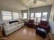 Bright living room with a ceiling fan, comfortable seating, and ample natural light through large windows at 1281 S Sioux Dr, Apache Junction, AZ 85119