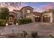 Elegant stone home with a large driveway, well-manicured landscaping, and a grand entrance at 13808 S Canyon Dr, Phoenix, AZ 85048