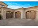 Spacious three-car garage with wooden doors and complementary stone and brick accents at 13808 S Canyon Dr, Phoenix, AZ 85048