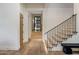 Bright hallway with wood floors, staircase with black metal railings, and access to a wine storage area at 13808 S Canyon Dr, Phoenix, AZ 85048