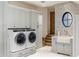 Bright laundry room with modern washer and dryer units, sink, and stylish finishes at 13808 S Canyon Dr, Phoenix, AZ 85048