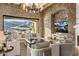 Bright living room with stone accents, a large TV, and mountain views through sliding glass doors at 13808 S Canyon Dr, Phoenix, AZ 85048