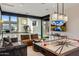 Modern living room with large windows, comfortable seating, and stylish air hockey game table at 13808 S Canyon Dr, Phoenix, AZ 85048