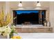 Stainless steel kitchen sink with bi-fold windows opening to an outdoor kitchen at dusk at 13808 S Canyon Dr, Phoenix, AZ 85048