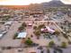 Sweeping aerial view highlighting a desert property with buildings, a pool, horse paddock and desert landscaping at 14215 E Calle De Las Estrellas Dr, Scottsdale, AZ 85262