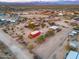 Wide aerial shot of the property, showcasing its layout, buildings, horse paddock, and desert surroundings at 14215 E Calle De Las Estrellas Dr, Scottsdale, AZ 85262