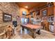 Rustic game room featuring a pool table, stone fireplace, and decorative Western accents at 14215 E Calle De Las Estrellas Dr, Scottsdale, AZ 85262