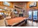 Cozy game room showcasing a pool table, stone fireplace, and natural light at 14215 E Calle De Las Estrellas Dr, Scottsdale, AZ 85262