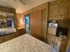 View of bedroom with bed, mirrored closet, and wooden cabinets at 1506 S Omaha Dr, Apache Junction, AZ 85119