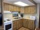 Cozy kitchen featuring wooden cabinets, white appliances, and a window over the sink at 1506 S Omaha Dr, Apache Junction, AZ 85119