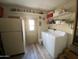 Well-equipped laundry room featuring washer, dryer and shelving for storage at 1506 S Omaha Dr, Apache Junction, AZ 85119