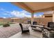 Covered patio in backyard with pavers and artifical turf with outdoor seating at 16789 W Moreland St, Goodyear, AZ 85338