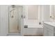 Bright bathroom with a glass-enclosed shower and a soaking tub at 16789 W Moreland St, Goodyear, AZ 85338