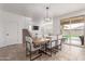 Bright dining area features a modern chandelier, neutral decor, and sliding door access to the backyard at 16789 W Moreland St, Goodyear, AZ 85338