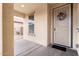 Inviting entryway features a charming storm door with wreath, window and concrete flooring at 16789 W Moreland St, Goodyear, AZ 85338