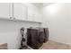 Bright laundry room with storage cabinets above and side-by-side washer and dryer at 16789 W Moreland St, Goodyear, AZ 85338