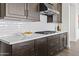 Kitchen counter with quartz countertops, subway tile backsplash, and stainless steel vent hood at 17205 W Middlebury St, Surprise, AZ 85388