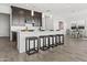 Wide kitchen island with barstools, pendant lighting, and views of the adjacent dining area at 17205 W Middlebury St, Surprise, AZ 85388