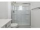 Bathroom featuring a walk-in shower with built in shelves and glass sliding door at 17745 W Carol Ave, Waddell, AZ 85355