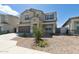 Inviting two-story home showcasing desert landscaping, a spacious driveway, and a charming covered entryway at 17745 W Carol Ave, Waddell, AZ 85355