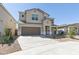 Two-story home with a neutral exterior, a two-car garage, and low-maintenance desert landscaping in the front yard at 17745 W Carol Ave, Waddell, AZ 85355