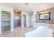 Modern bath with glass enclosed shower and standalone tub in an elegant home at 18430 E Ashridge Dr, Queen Creek, AZ 85142