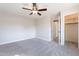 A bright bedroom features a closet, carpeted flooring, neutral walls, and a modern ceiling fan at 18430 E Ashridge Dr, Queen Creek, AZ 85142