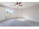 Bright bedroom with a large window, carpeted flooring, and a modern ceiling fan at 18430 E Ashridge Dr, Queen Creek, AZ 85142