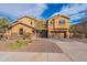 Elegant two-story home featuring a desert landscape, stone accents and a gated entry at 18430 E Ashridge Dr, Queen Creek, AZ 85142